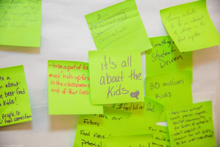A sticky note says "it's all about the kids," with other sticky notes in the background