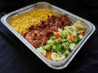 A large metal tray filled with corn, barbecue pork, and a mixture of broccoli, carrots and cauliflower