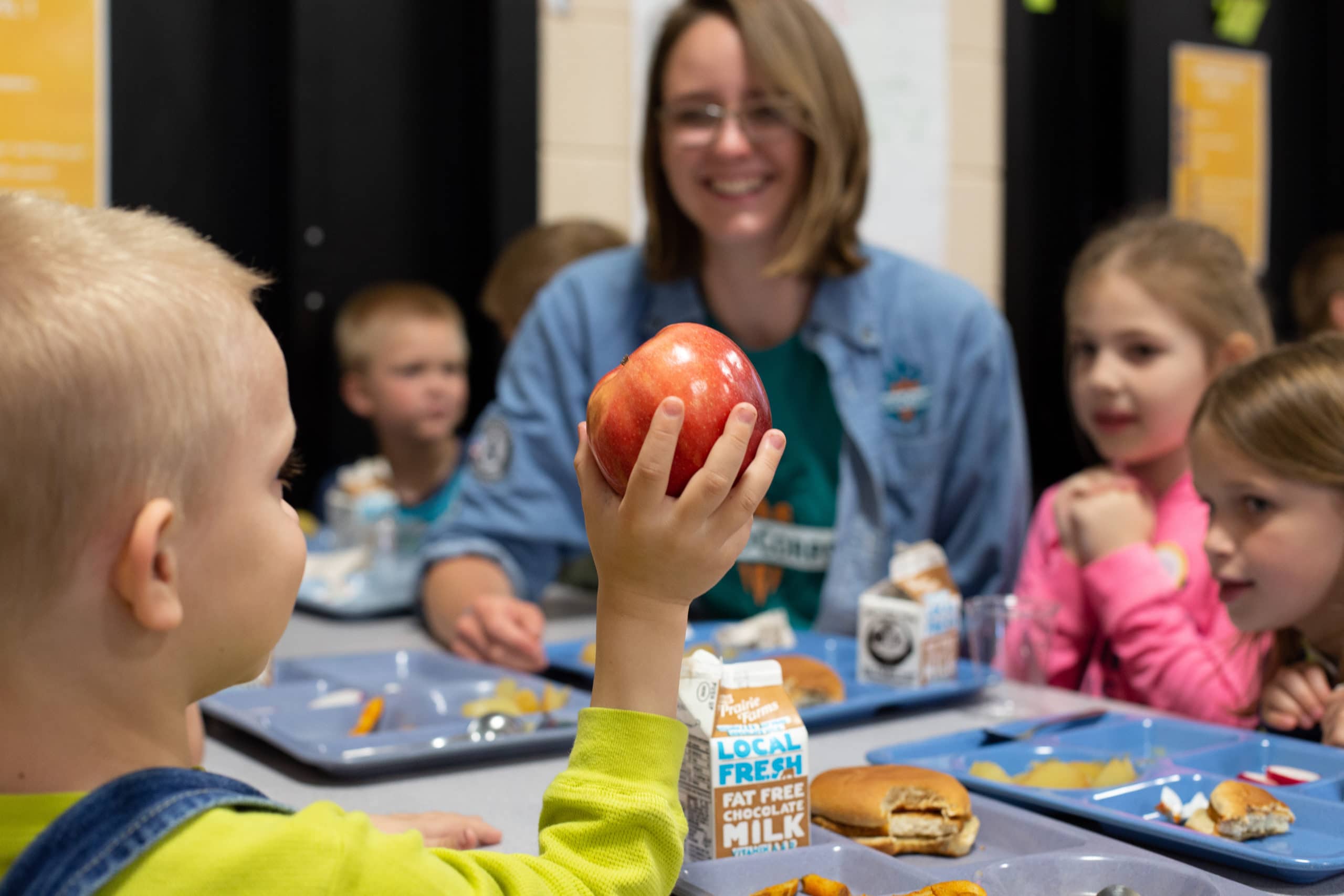 A FoodCorps member samples apples with kids. CNR helps more kids access food in school.