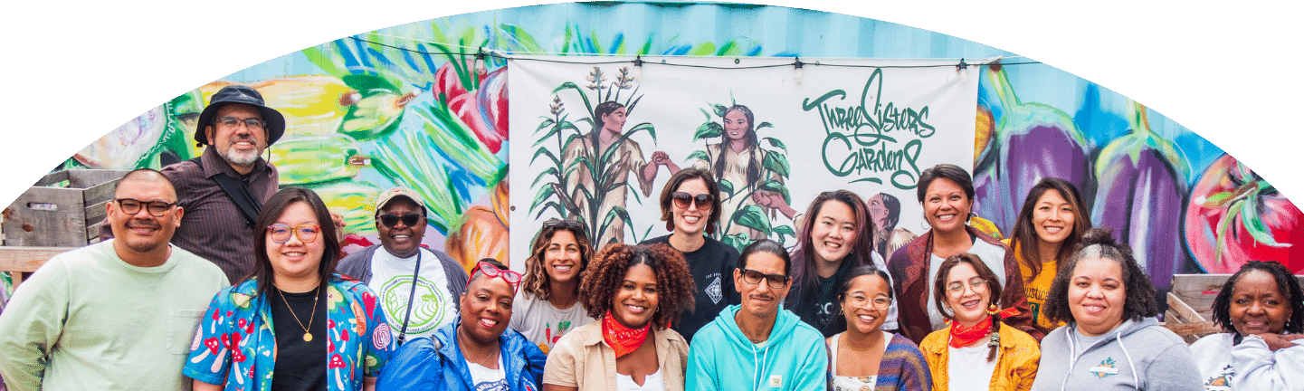 FOLCS members in front of a sign that says "Three Sisters Garden"