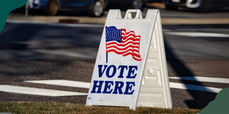 A plastic VOTE HERE sign on a grassy corner. Voters made their voices heard on their policy priorities this election season.