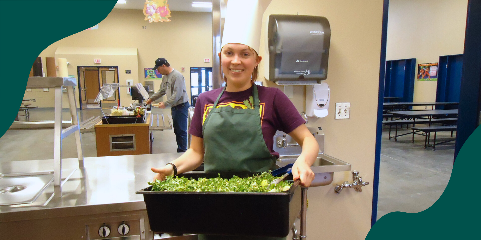 Food access and anti-hunger advocate Anina Estrem holds a tray of greens in a school cafeteria.