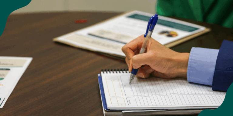 Behind the scenes at a policy workshop for FoodCorps alums: a close-up of a hand holding a pen and taking notes in a professional-looking setting.