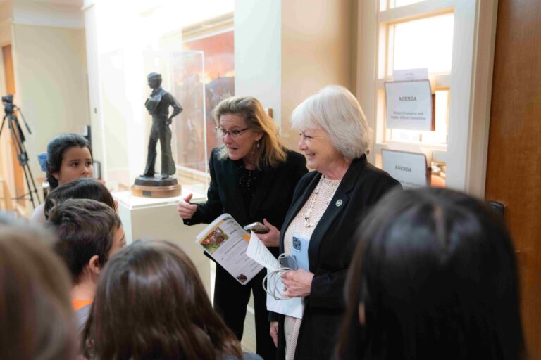Two adult women talking to students in the New Mexico State Capitol